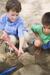 Мальчики играют в песочнице